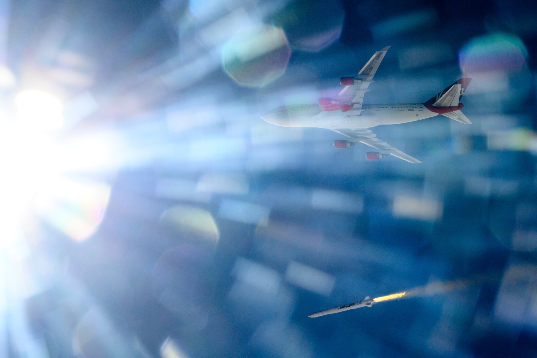 LauncherOne in flight through atmospheric light.