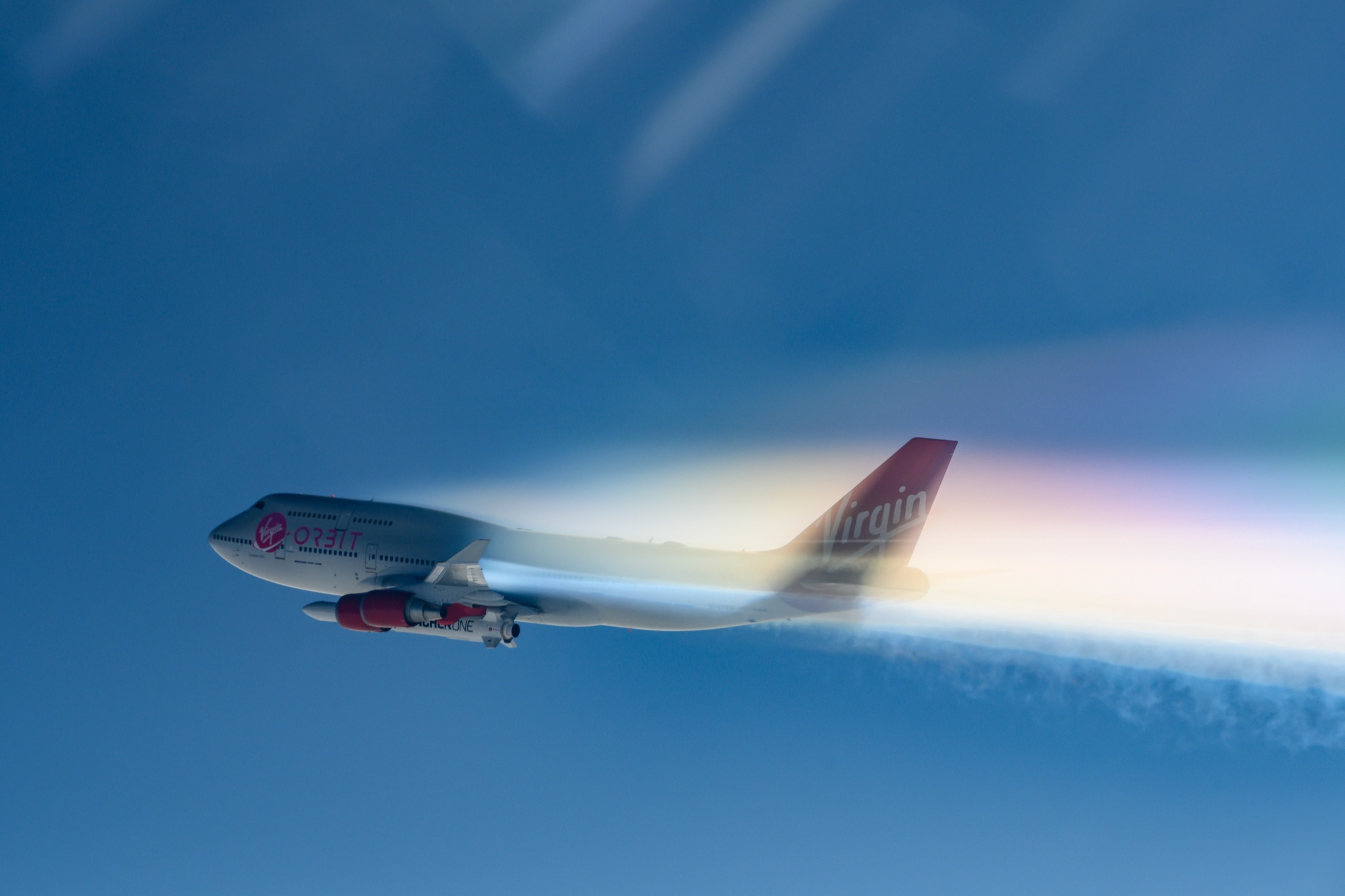 Cosmic Girl carrying LauncherOne through bright atmospheric streaks.