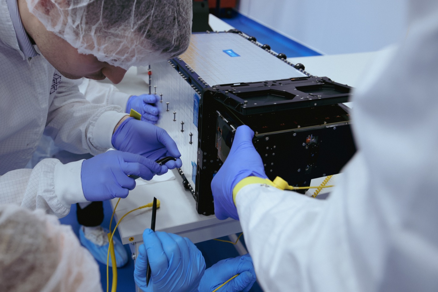 Scientists working with satellite hardware.