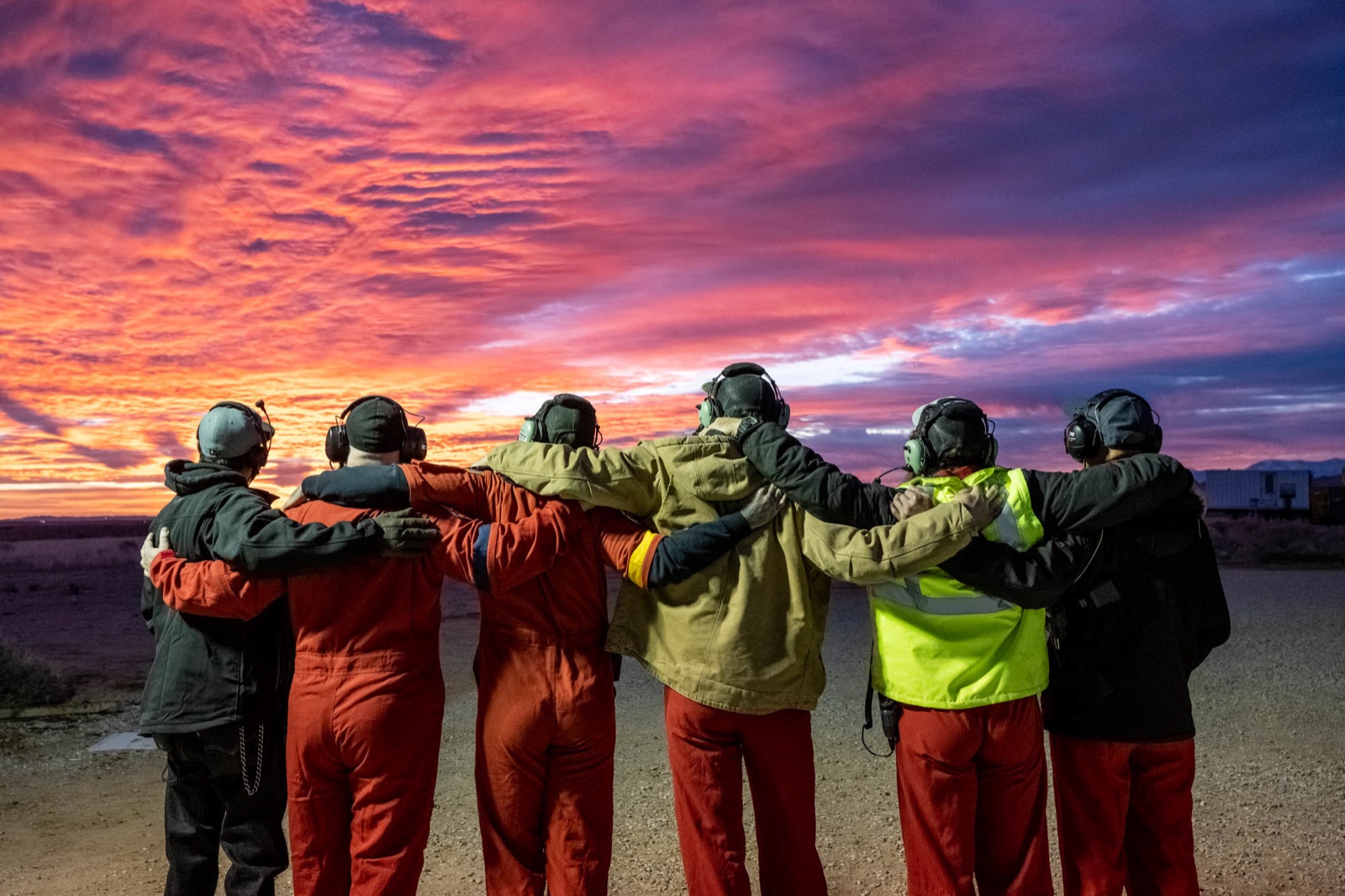 Mission teammates together beneath a dramatic sky.
