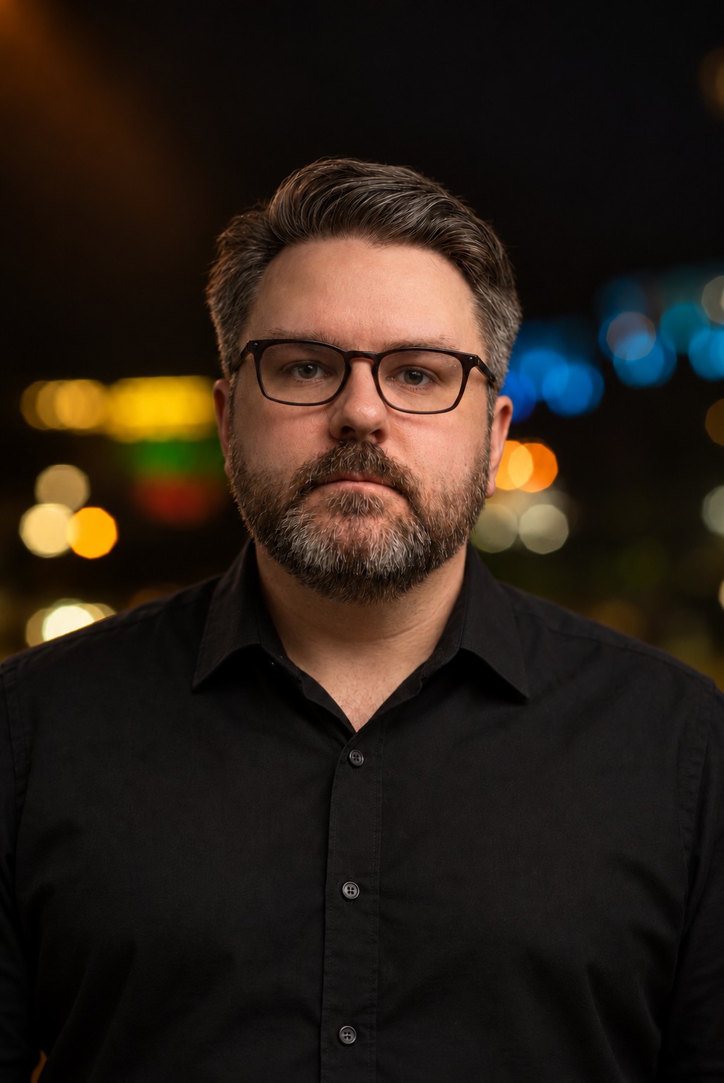 Daniel Jarvis against a softly lit nighttime background.